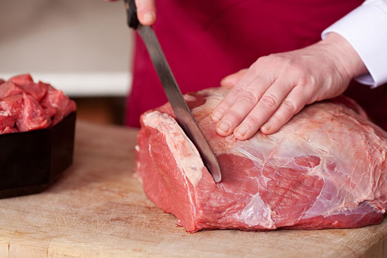 Butcher Cutting Raw Meat