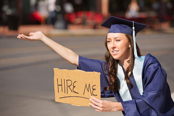 Female College Graduate Holding a 'Hire Me' Sign