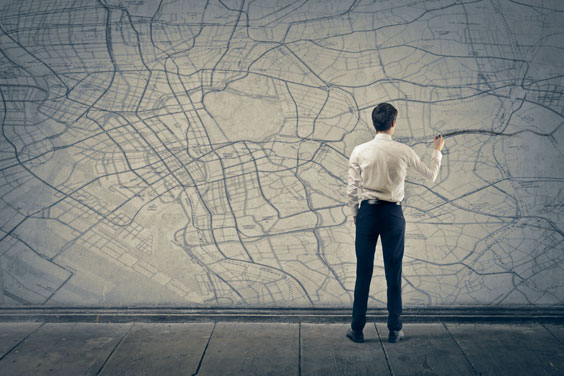 Man Marking a Route on a Map