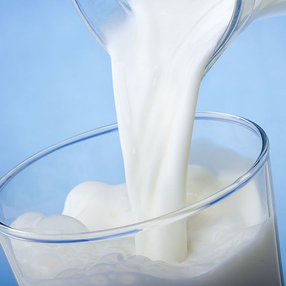 Milk Pouring From a Pitcher into a Glass