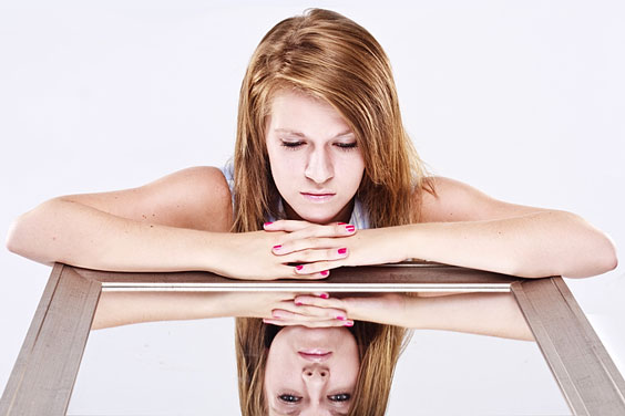 Young Woman Resting her Arms on a Mirror