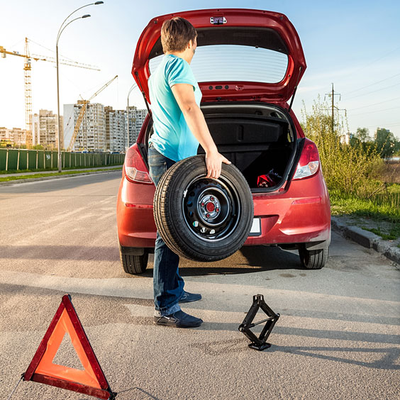 Man Holding Spare Wheel and Tire