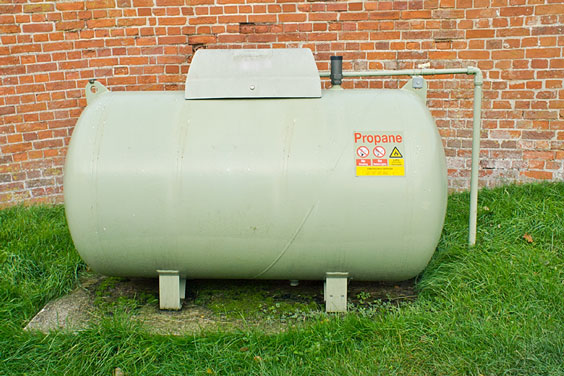 Propane Tank Next to a Brick Wall